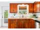 This kitchen features wooden cabinets, granite countertops, and a view of the lush outdoors at 302 Pavonia Rd, Nokomis, FL 34275