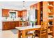 Charming kitchen features wooden cabinets, stainless steel refrigerator, and a cozy dining area at 302 Pavonia Rd, Nokomis, FL 34275