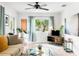 Cozy living area featuring comfortable seating, a sleek ceiling fan, and a view of the landscaped yard at 302 Pavonia Rd, Nokomis, FL 34275