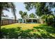 Exterior of home with well-manicured backyard, inviting patio, and lush tropical surroundings at 302 Pavonia Rd, Nokomis, FL 34275