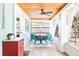 Inviting sunroom with a wooden ceiling, ceiling fan, and charming blue outdoor dining set at 302 Pavonia Rd, Nokomis, FL 34275
