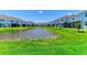 View of the backyards of identical blue townhomes overlooking a pond at 305 Via Tuscany Ave, Sarasota, FL 34243