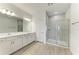 Modern primary bathroom with dual vanities, a glass-enclosed shower, and tile flooring at 305 Via Tuscany Ave, Sarasota, FL 34243