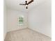 Bright bedroom with plush carpeting and a ceiling fan, with windows providing ample natural light at 305 Via Tuscany Ave, Sarasota, FL 34243