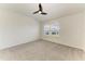 Bedroom featuring a ceiling fan, neutral carpet, and large windows providing natural light at 305 Via Tuscany Ave, Sarasota, FL 34243