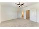 Bright, carpeted bedroom boasts a ceiling fan and two doorways to other rooms within the home at 305 Via Tuscany Ave, Sarasota, FL 34243