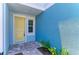 Inviting entryway with yellow front door, side window, and brick paver landing at 305 Via Tuscany Ave, Sarasota, FL 34243