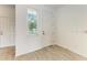 Bright entryway featuring wood-look tile flooring, a window with blinds, and white doors at 305 Via Tuscany Ave, Sarasota, FL 34243