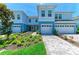 Beautiful blue townhome with a two-car garage and lush landscaping in the front yard at 305 Via Tuscany Ave, Sarasota, FL 34243