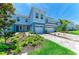 Beautiful blue townhome with a two-car garage and lush landscaping in the front yard at 305 Via Tuscany Ave, Sarasota, FL 34243