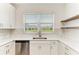 Modern kitchen featuring white cabinets, stainless steel dishwasher, and quartz countertops at 305 Via Tuscany Ave, Sarasota, FL 34243