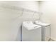 A modern laundry room features a white washer and dryer with wire shelving at 305 Via Tuscany Ave, Sarasota, FL 34243