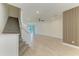 Spacious living room with wood-look tile flooring, ceiling fan, and staircase at 305 Via Tuscany Ave, Sarasota, FL 34243