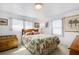 Bright bedroom featuring two windows, a floral-patterned bedspread, and wood furniture at 3214 Sycamore Ter, Sarasota, FL 34237