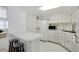 Bright kitchen offering white cabinets, white appliances, tile flooring and a breakfast bar at 3214 Sycamore Ter, Sarasota, FL 34237