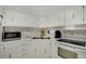 Bright kitchen featuring white cabinets, countertops, stainless steel sink, and appliances at 3214 Sycamore Ter, Sarasota, FL 34237