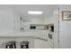 All white kitchen with quartz countertops, black and white bar stools, and skylight at 3214 Sycamore Ter, Sarasota, FL 34237