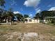 Modest single-Gathering home with a small front yard, surrounded by mature trees under a bright, partly cloudy sky at 322 34Th W St, Bradenton, FL 34205