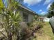 Home exterior with overgrown foliage, jalousie windows, and blue sky at 322 34Th W St, Bradenton, FL 34205