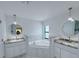 Elegant bathroom with dual vanities, granite countertops, a soaking tub, and modern fixtures at 3386 Irma St, North Port, FL 34291