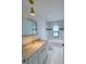Well-lit bathroom features granite countertops, a rectangular mirror, and a bathtub with tiled walls at 3386 Irma St, North Port, FL 34291