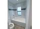 Elegant bathroom with white tiled walls, a deep soaking tub, and showerhead at 3398 Escobar Ln, North Port, FL 34286