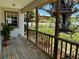 Back porch featuring wood floors, railing, backyard views, a treehouse, and plants at 3828 6Th W Ave, Palmetto, FL 34221