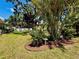 Lush backyard featuring a treehouse, palm trees, plants, green grass, and blue skies at 3828 6Th W Ave, Palmetto, FL 34221