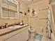 Bathroom featuring a single sink vanity, a toilet, and a shower with decorative coastal accents at 3828 6Th W Ave, Palmetto, FL 34221