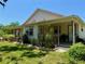 Side view of the home showing landscaping, covered porch, neutral color scheme, and window frames at 3828 6Th W Ave, Palmetto, FL 34221