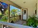 Inviting front porch with plants, wood railing, and a door with glass panes at 3828 6Th W Ave, Palmetto, FL 34221
