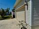 Attached garage with well-maintained siding, beautiful flowering bush, and driveway at 3828 6Th W Ave, Palmetto, FL 34221
