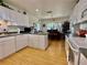 Bright kitchen featuring white cabinets, laminate wood floors, and views of the dining area at 3828 6Th W Ave, Palmetto, FL 34221