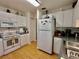 Galley kitchen featuring laminate floors, white appliances and cabinets at 3828 6Th W Ave, Palmetto, FL 34221