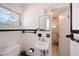 Cozy bathroom featuring white tiled walls and black trim, a pedestal sink, and an adjacent room at 385 Avenida Madera, Sarasota, FL 34242