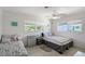 Bright bedroom featuring two beds, ceiling fan, and natural light from two windows at 385 Avenida Madera, Sarasota, FL 34242