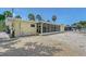 Home exterior with a screened patio, a gravel yard, and tropical palm trees in the background at 385 Avenida Madera, Sarasota, FL 34242