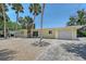 Charming one-story home with a well-manicured lawn, lush landscaping, and inviting curb appeal at 385 Avenida Madera, Sarasota, FL 34242
