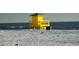 Bright yellow lifeguard stand on a sandy beach with seagulls, ensuring safety for swimmers at 385 Avenida Madera, Sarasota, FL 34242