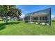 Exterior view of home featuring grassy yard and screened-in patio area at 4220 Miriana Way, Sarasota, FL 34233