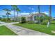 Single-Gathering home with manicured front yard, tropical plants and lush green grass along the sidewalk at 4220 Miriana Way, Sarasota, FL 34233