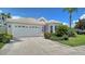 Well-maintained house with a two-car garage, nicely manicured lawn and tropical plants in front of the house at 4220 Miriana Way, Sarasota, FL 34233
