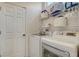 Practical laundry room equipped with modern washer and dryer, shelves, and ample storage space at 4220 Miriana Way, Sarasota, FL 34233