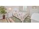 Cozy bedroom with a tropical style bed, wicker furniture, decorative rug, and ample natural light from the window at 42250 Ramble Rd, Punta Gorda, FL 33982