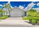 Beautiful single-story home with a two-car garage, lush landscaping, and a welcoming front entrance at 42250 Ramble Rd, Punta Gorda, FL 33982