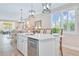 Bright kitchen island featuring a stainless steel dishwasher, pendant lighting, and seating at 42250 Ramble Rd, Punta Gorda, FL 33982