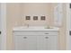 Laundry room showcasing sink with white cabinets below, 