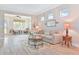 Comfortable living room features a large sofa, decorative rug, and views of the screened in porch and windows with shades at 42250 Ramble Rd, Punta Gorda, FL 33982