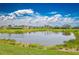 Picturesque view of the pond reflecting the cloudy sky, showcasing the tranquil setting of the community at 42250 Ramble Rd, Punta Gorda, FL 33982