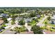 The aerial view shows a charming home nestled in a neighborhood, surrounded by lush greenery and palm trees at 4308 Kingston Loop, Sarasota, FL 34238